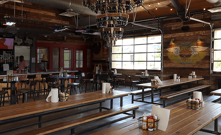 A restaurant with wooden tables and chairs, expertly designed by a Dallas restaurant consultant.